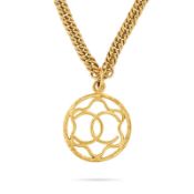 CHANEL, A LONG CC PENDANT NECKLACE comprising a circular openwork pendant in gold tone metal with