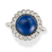 AN ART DECO SAPPHIRE AND DIAMOND CLUSTER RING set with a round cabochon sapphire of approximately 4.