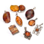 A GROUP OF SILVER AND AMBER PENDANTS