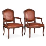 A PAIR OF LOUIS XV STYLE CARVED AND LEATHER UPHOLSTERED FAUTEUILS