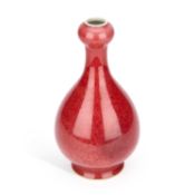 A CHINESE COPPER-RED GLAZED GARLIC NECK BOTTLE VASE