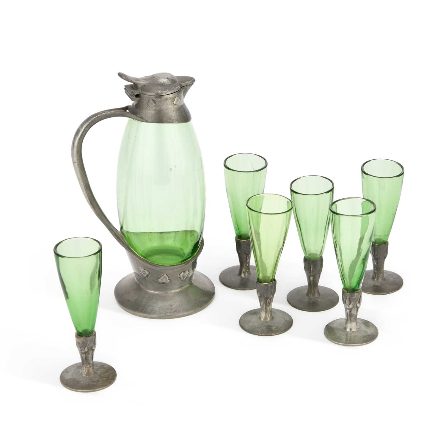 ARCHIBALD KNOX (1864-1933) FOR LIBERTY & CO A TUDRIC PEWTER AND GREEN GLASS DECANTER WITH SIX LIQUOR