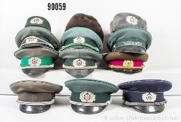 Konv. 11 Kopfbedeckungen DDR, überwiegend mit Effekten, dabei u.a. Volkspolizei, ...