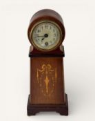 An Edwardian mahogany cased mantle clock, inlaid ribbon and bell husk decoration, circular dial with