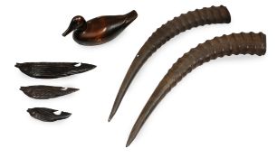 A pair of springbok horns along with a wooden decoy duck and three graduated Chinese hardwood fish.