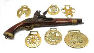A decorative brass mounted wooden flintlock pistol, together with six horse brasses, one for the