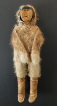 Inuit figure, carved wood, hand-stitched fur clothes, 28cm high – together with model of kayak, wood