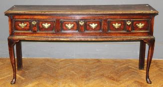An 18th century oak low dresser of good colour. The moulded rectangular top over three twin panel