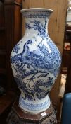 A large Chinese blue and white decorative vase with peacock and foliage detail.