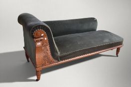 A 19th century green velvet chaise longue on turned supports and castors on an oak frame.