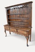 George II oak kitchen dresser comprising an ornate plate rack with three shelves and pierced apron