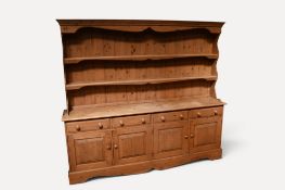 A large 20th century  pine kitchen dresser with plate rack and shelves on a base of four frieze