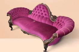 Ornate carved Victorian mahogany two-seater sofa/chaise with serpentine front and upholstered in