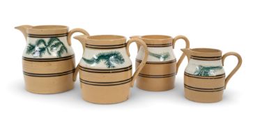 A graduated harlequin set of four mocha ware jugs, c.1820, each decorated with a band of seaweed in 