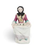 A Chelsea vase figure of a flower seller, c.1760, modelled as a woman seated and holding the sides o