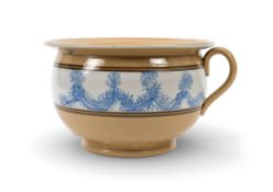 A mocha ware chamber pot, decorated with a band of raised blue seaweed tendrils on white against a b
