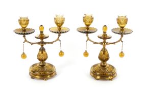 A pair of Regency gilt brass and amber glass two-branch candelabra, early 19th century, cut with an 