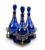 A set of three blue glass decanters and stoppers, c.1800-10, of mallet form with flattened stoppers,