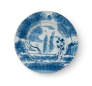 A small delftware plate, c.1720, probably London, painted in blue with a figure blowing a hunting ho