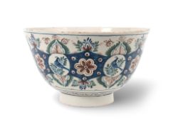 A massive delftware punchbowl, c.1720-30, the sides painted in blue, red and green with bird roundel