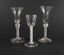 Three wine glasses, c.1750-60, two with waisted bell bowls and teared bases, raised on airtwist stem