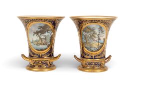 A pair of Derby vases and stands, c.1815-25, the flared forms painted with landscape views, one with