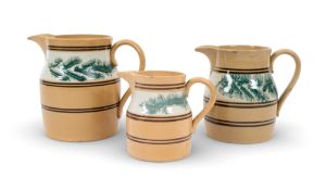 A graduated set of three mocha ware jugs, c.1820, painted with bands of seaweed fronds in greenish-b