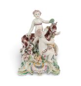 A Bow figure group of putti and a goat, c.1760, one seated astride its back, two others flanking it 