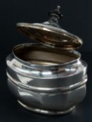 Silver: a tea caddy, rubbed marks but probably Chester 1898, with hinged lid and ebonised finial. 10