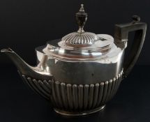 Silver: a teapot, London 1910, with half gadrooned body and lid, and ebonised handle and finial. 25c