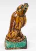Asian Art - A Chinese sancai-glazed roof tile, modelled with a mythical dog seated on its haunches w