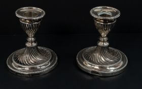 Silver: a pair of dwarf candlesticks of wrythen form, London 1910, bearing the mark for the Goldsmit