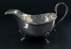 Silver: a sauce boat, London 1957, with reeded decoration to the rim and standing upon three hoofed 