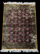 Rugs: a 20th century Bokhara rug, deep red diamonds within a pale brown and blue hatched border. App