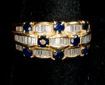 Jewellery: a yellow metal ring, marked 750 and testing as 18ct gold, pave set with panels of baguett