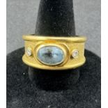 Jewellery: an unmarked yellow metal ring, testing as 18ct gold, collet set with an oval aquamarine m