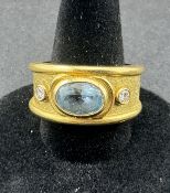 Jewellery: an unmarked yellow metal ring, testing as 18ct gold, collet set with an oval aquamarine m