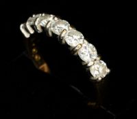 Jewellery: an 18ct yellow gold ring set a row of seven diamonds, totalling approximately 1ct. UK siz