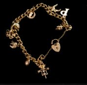 Jewellery: a 9ct yellow gold curb link charm bracelet with heart shaped clasp, suspended with nine c