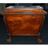 Furniture: an early 19th century mahogany cellarette of sarcophagus form, standing upon four paw fee