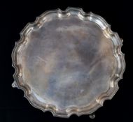 Silver: an unengraved salver, Birmingham 1926, with piecrust rim and standing upon three hoofed feet