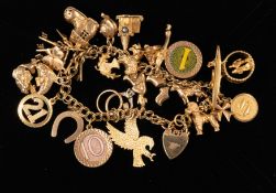 Jewellery: a 9ct gold bracelet with heart shaped clasp, suspended with at least 24 charms including 