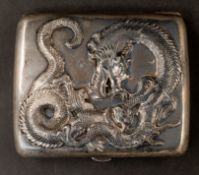 Silver: an unmarked Chinese white metal cigarette case, cast in high relief with a coiled dragon to 