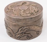 Silver: a Chinese white metal cylindrical box, testing as silver, decorated in high relief with a si