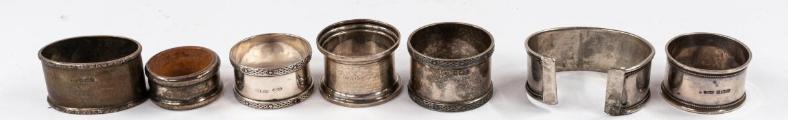 Silver: Six assorted silver napkin rings and a torque-style silver bangle set with coral and turquoi