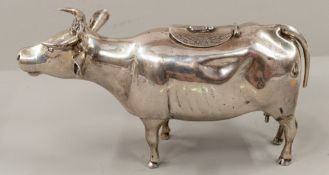 Silver: a Dutch white metal cow creamer, modelled standing four square with a hinged panel to the ba