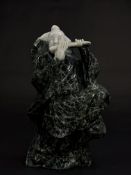 A Chinese hardstone carving of a musician, probably 19th century, the figure standing and playing th