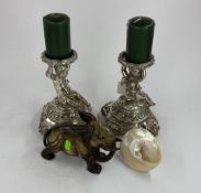 Decorative Arts: a pair of silvered bronze candlesticks in the form of seated cherubs each holding a