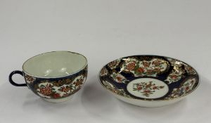 Ceramics: a Worcester tea cup and saucer, c.1760-70, painted with panels of Oriental flowers and pla