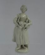 Ceramics: A French porcelain figure of a peasant girl, c.1770, standing barefoot and holding a fierc